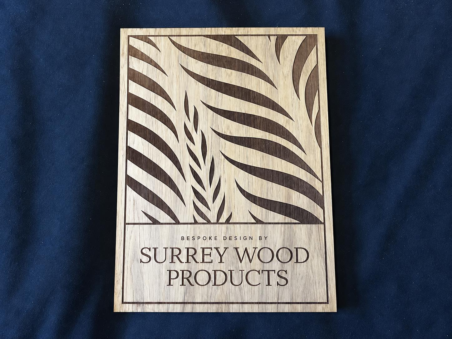 Wooden panel with an engraved leaf pattern and Surrey Wood Products lettering